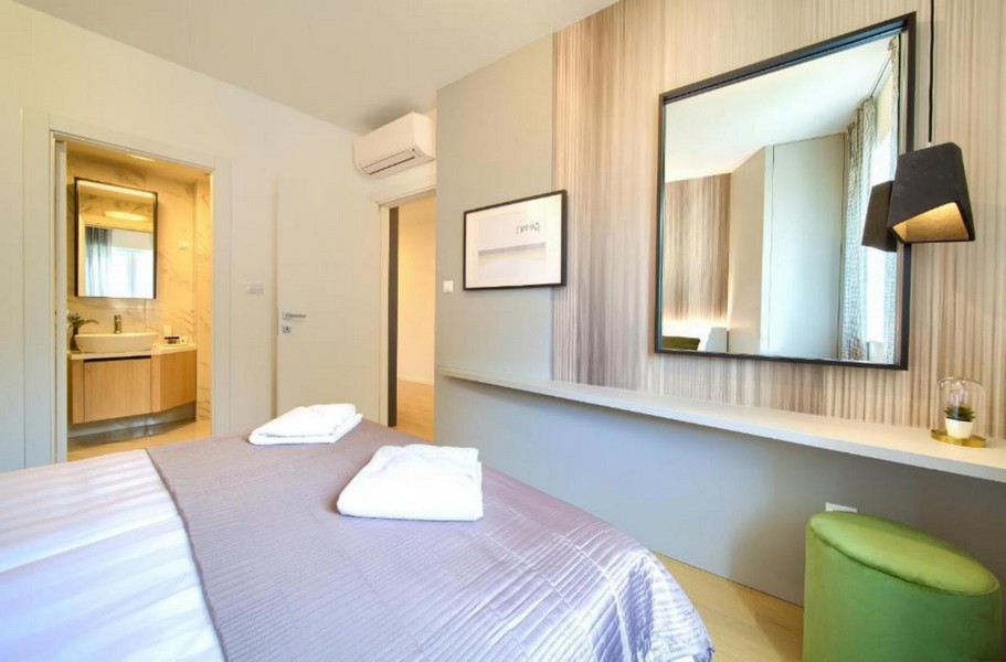 Sypialnia z dostępem do łazienki i lustrem