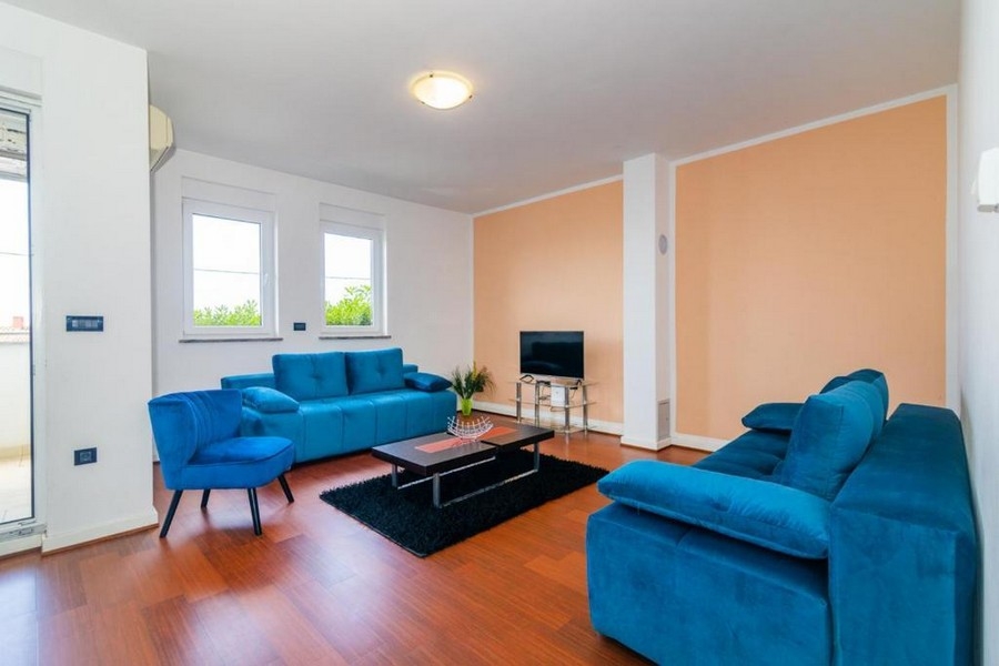 Część dzienna z dwiema turkusowymi kanapami.