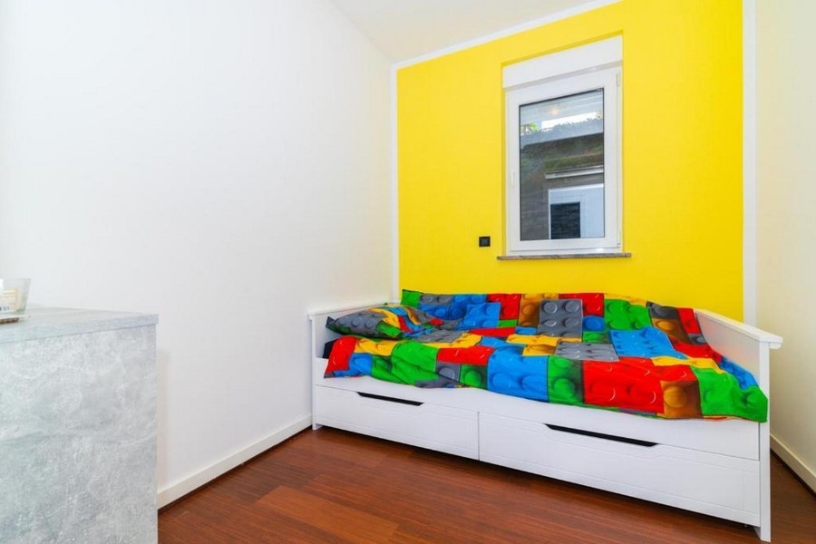 Druga sypialnia z łóżkiem pojedynczym i kolorową ścianą