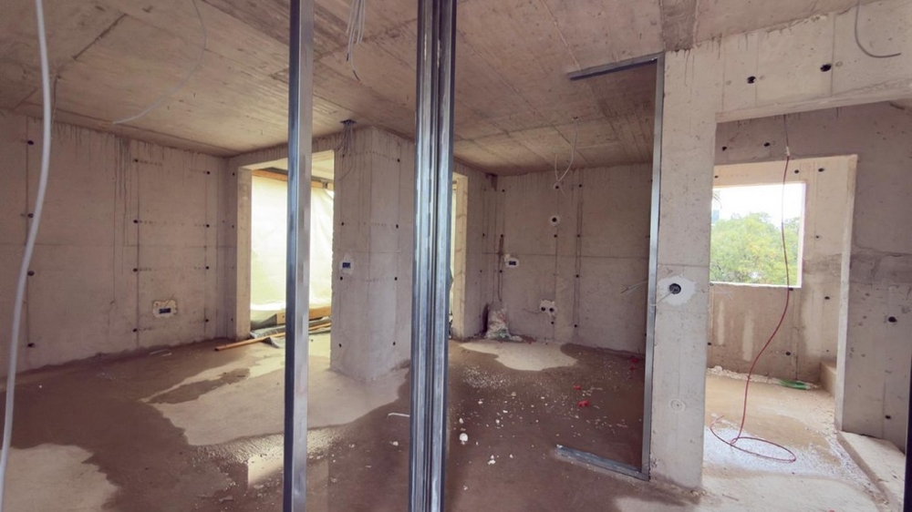 Otwarta część dzienna w stanie surowym z widokiem na okno i morze