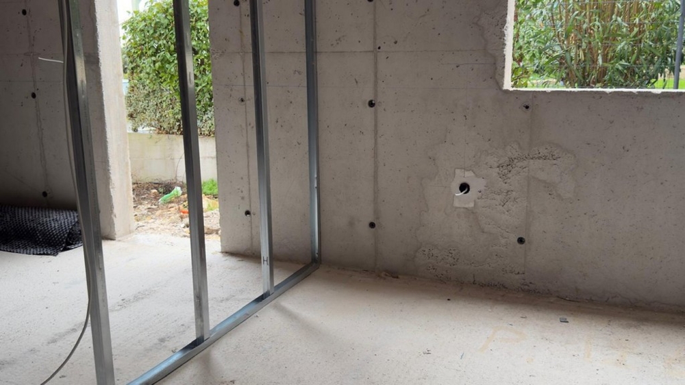 Pokój w stanie surowym z oknem i wyjściem na zewnątrz