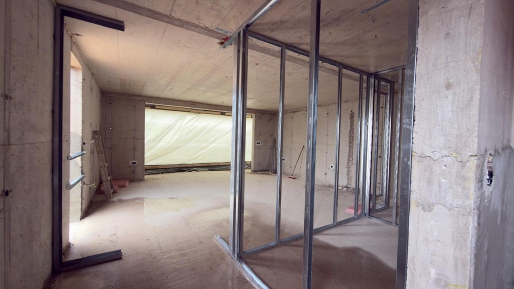 Otwarta część dzienna w stanie surowym z dużym oknem frontowym