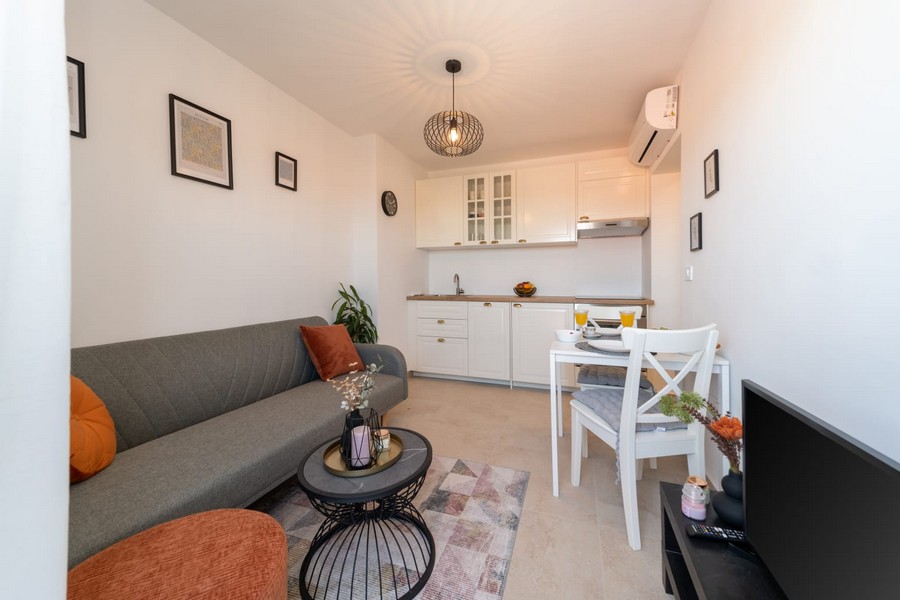Pokój dzienny z sofą, stołem i otwartą kuchnią