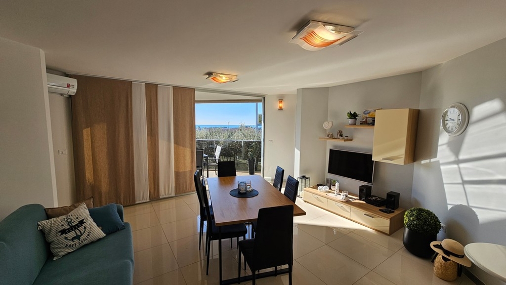 Pokój dzienny z wyjściem na taras i widokiem na morze