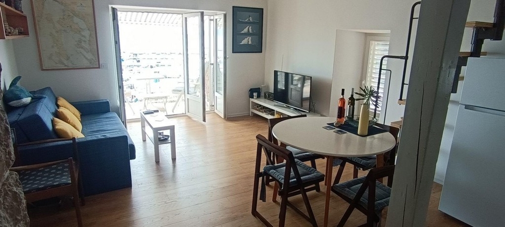 Część dzienna z sofą, stołem jadalnym i wyjściem na balkon z widokiem na morze