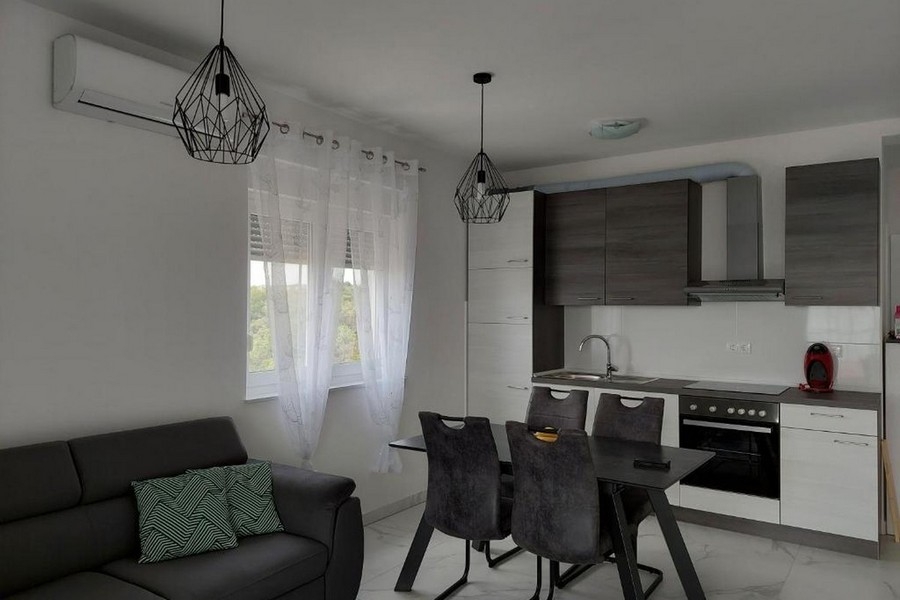 Otwarty salon i kuchnia z nowocześnie wyposażoną kuchnią i stołem jadalnym