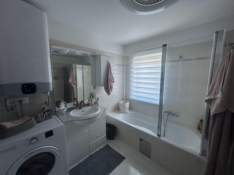 Łazienka z wanną, umywalką i pralką