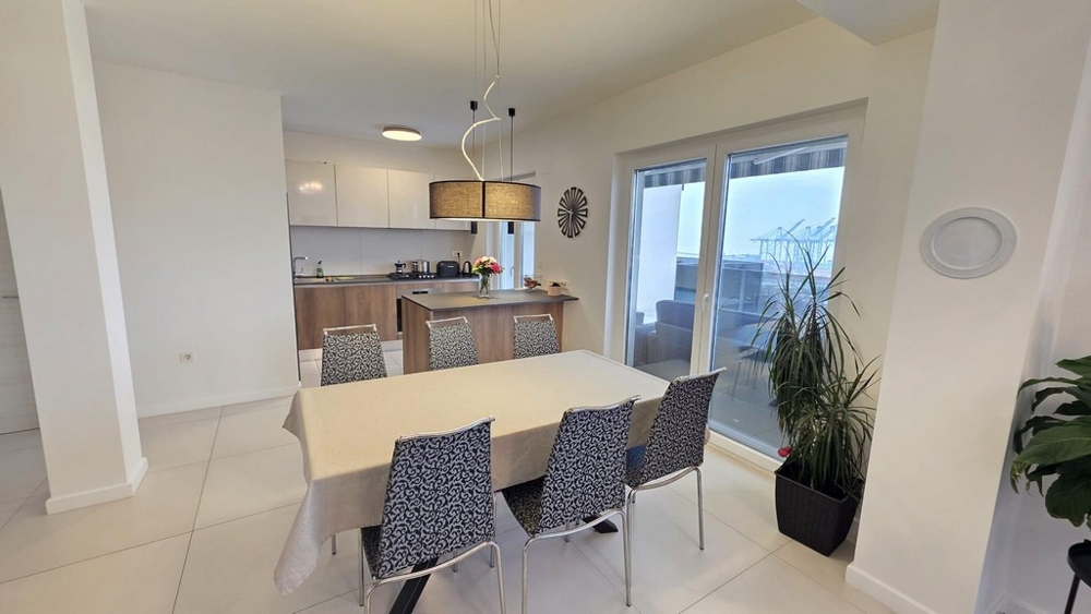 Jadalnia ze stołem i sześcioma krzesłami oraz wyjściem na taras