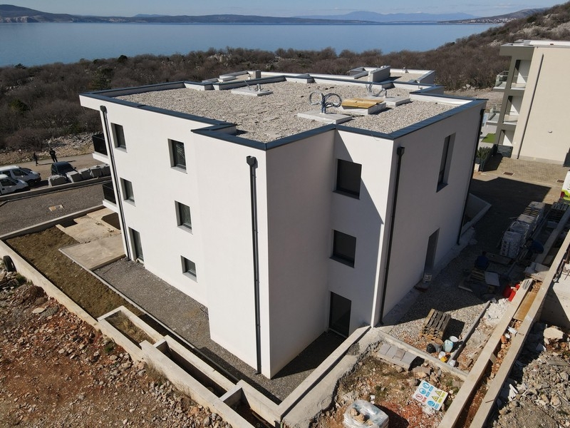 Nowy apartamentowiec z płaskim dachem i nowoczesną architekturą w pobliżu wybrzeża