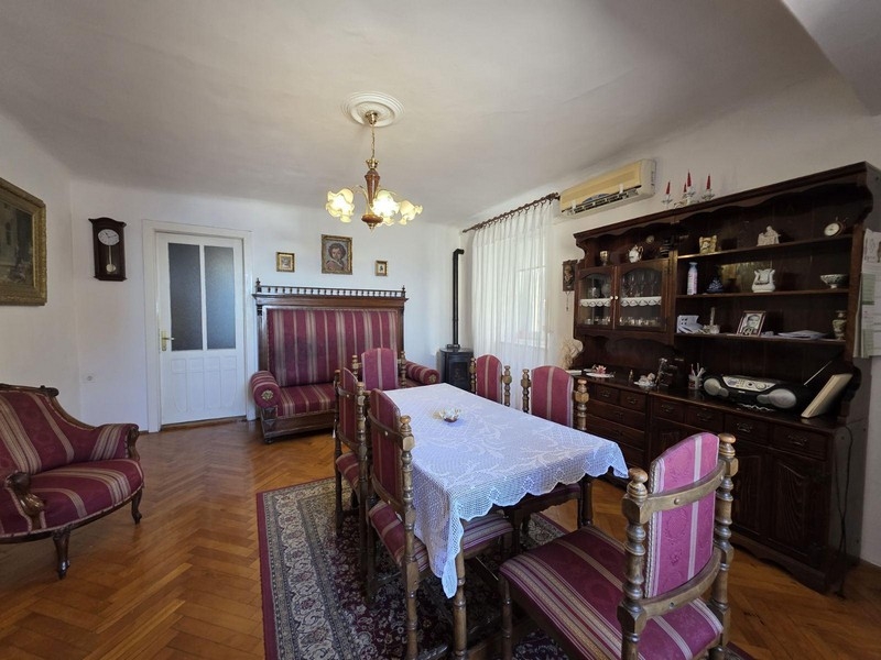 Pokój dzienny z klasycznymi meblami i dużym stołem jadalnym