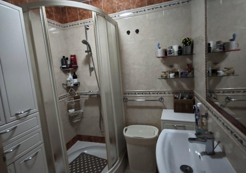 Łazienka z prysznicem, umywalką i lustrem