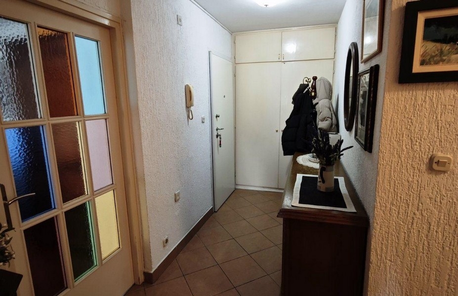 Strefa wejściowa mieszkania z garderobą i zabudowaną szafą