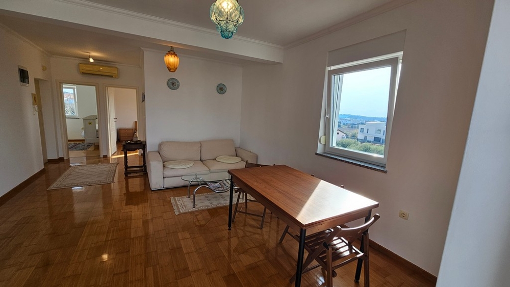 Pokój dzienny ze stołem jadalnym i widokiem na morze w Novigradzie