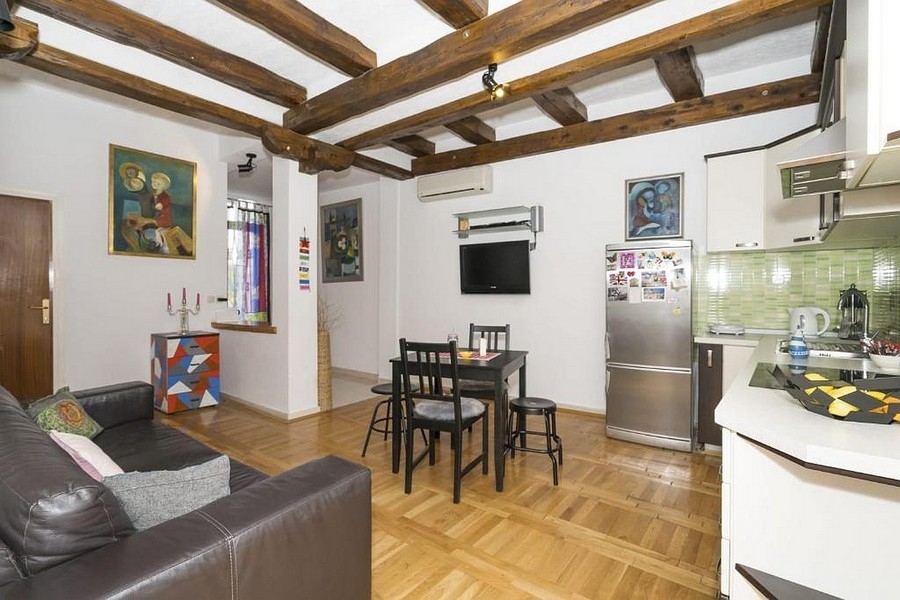 Część dzienna z kuchnią i jadalnią oraz drewnianymi belkami stropowymi