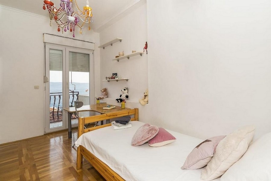 Pokój dziecięcy z łóżkiem i dostępem do balkonu z widokiem na morze