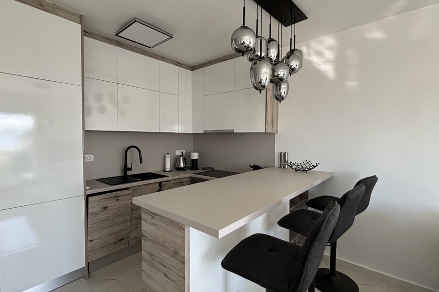 Nowoczesna kuchnia z wyspą i stołkami barowymi