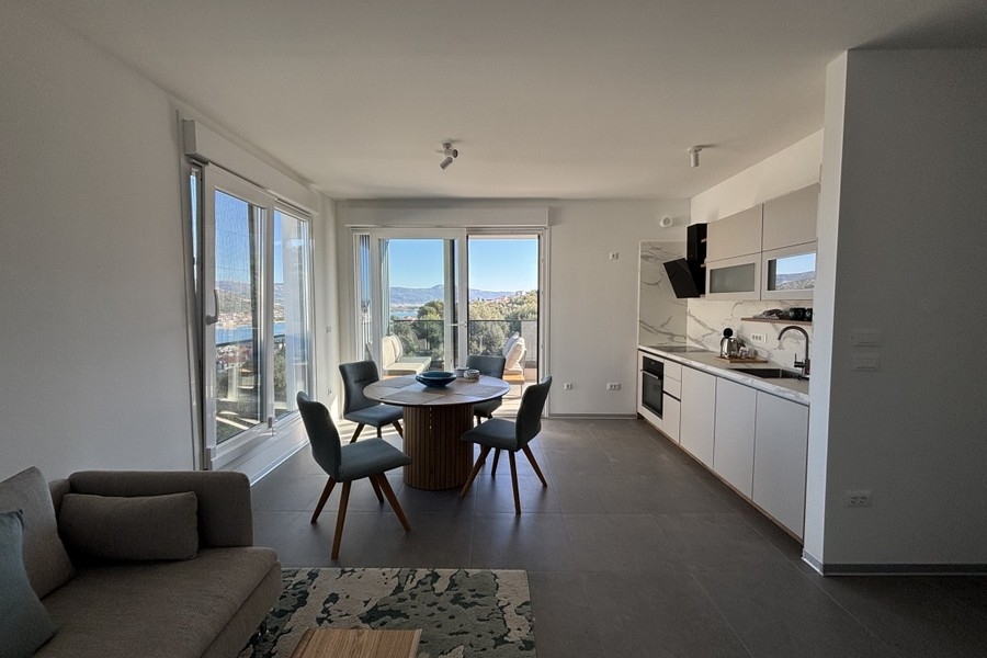 Jasny salon z dużymi oknami i widokiem na morze