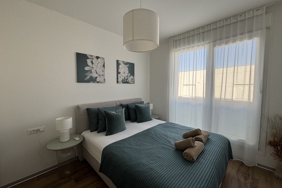 Sypialnia z podwójnym łóżkiem i dużymi oknami