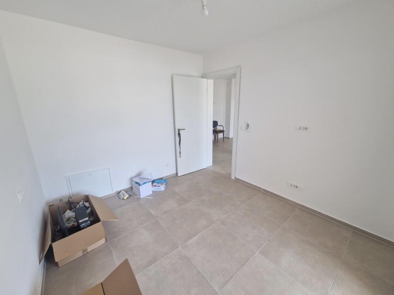 Pokój z podłogą wyłożoną kafelkami i neutralnymi meblami