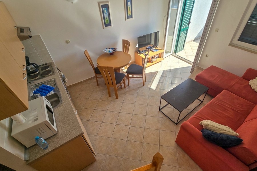 Jasny salon z otwartą kuchnią i wyjściem na balkon