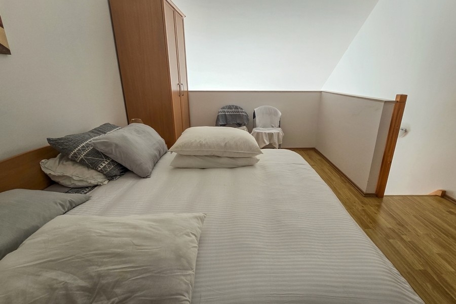 Część sypialna na antresoli z podwójnym łóżkiem i szafą