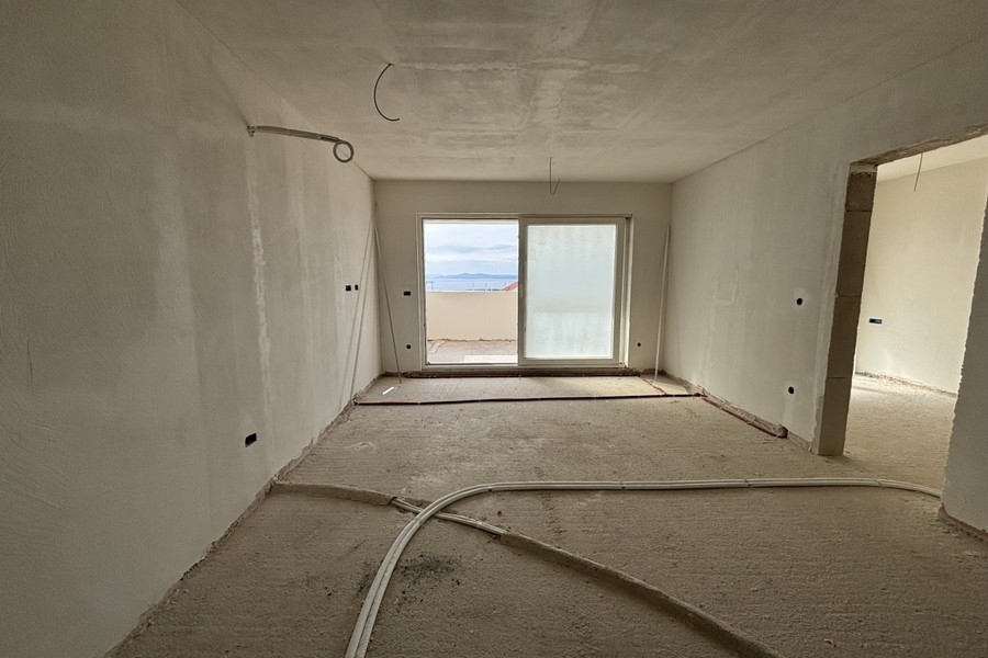 Widok wnętrza otwartej części dziennej z widokiem na kuchnię i przedpokój