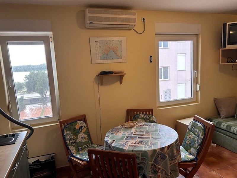 Część dzienna i jadalna z grupą okrągłego stołu i widokiem na morze przez okno