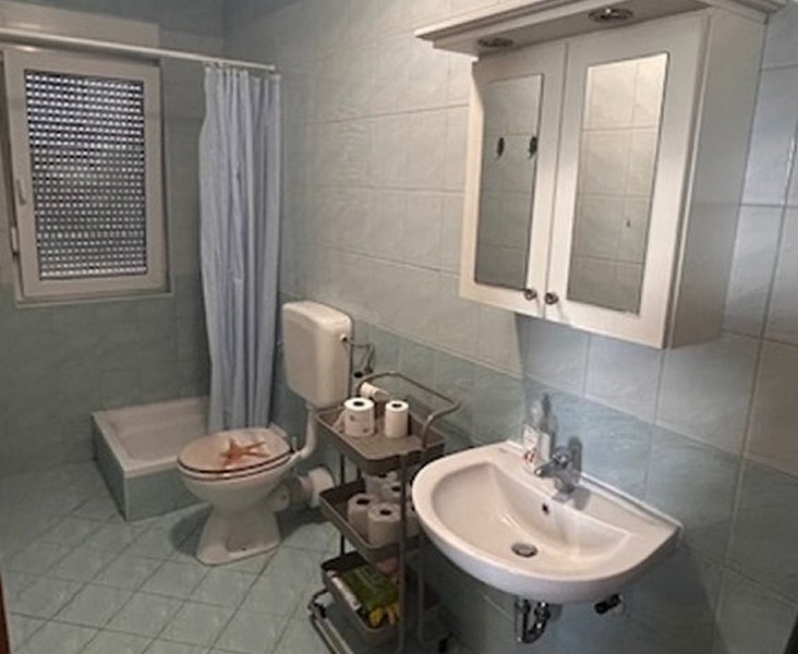 Łazienka z prysznicem, umywalką i oknem