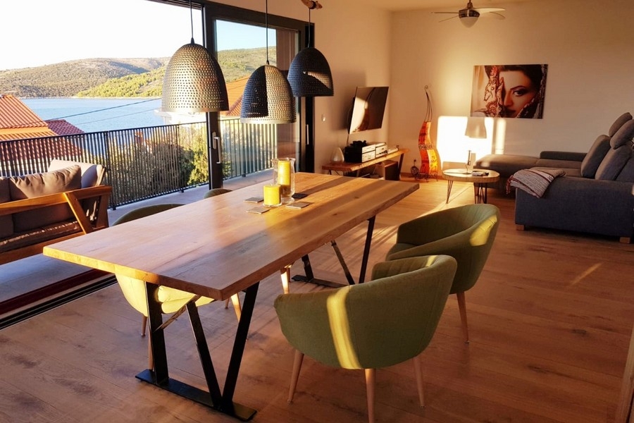 Otwarta część dzienna z sofą, stołem jadalnym i dostępem do balkonu