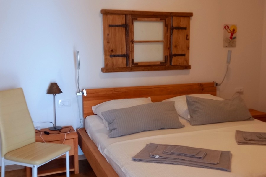 Sypialnia z podwójnym łóżkiem i prostym umeblowaniem