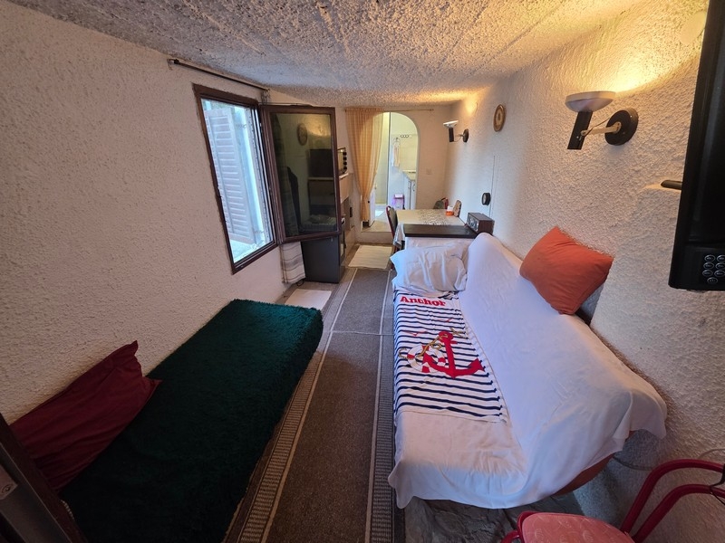 Wąski salon z miejscami do siedzenia i oknem wychodzącym na ulicę