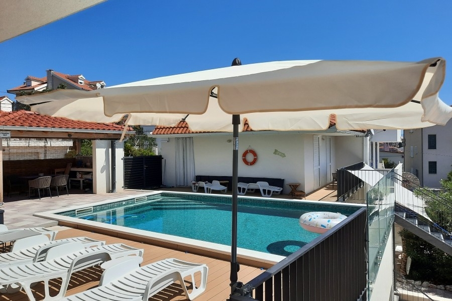 Teren basenu z tarasem słonecznym i leżakami