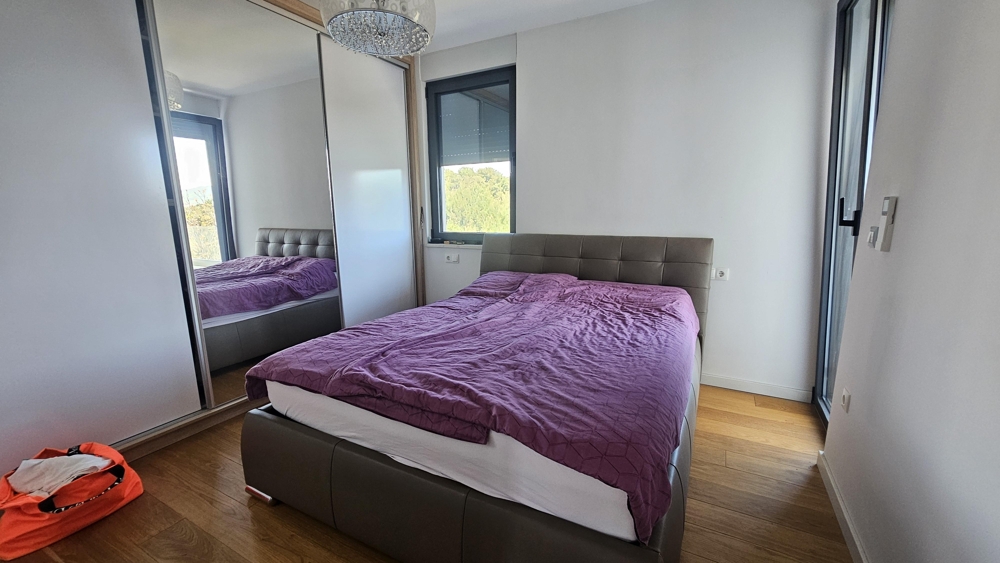 Sypialnia z szafą z lustrem i podwójnym łóżkiem