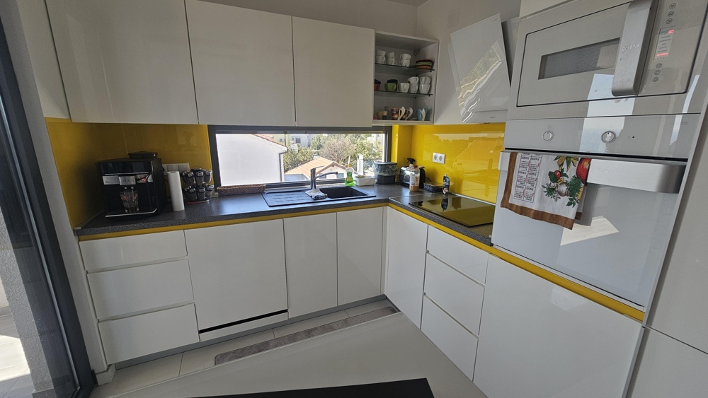 Nowoczesna kuchnia z zabudową AGD i oknem