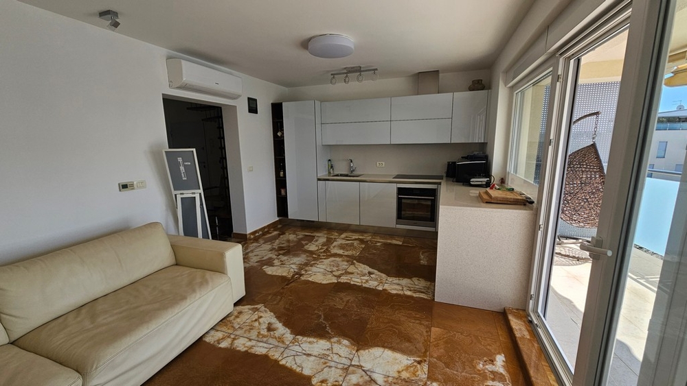 Otwarty salon z nowocześnie wyposażoną kuchnią i wyjściem na taras