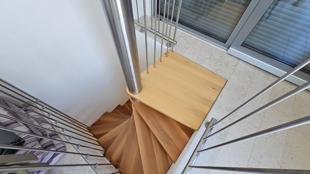 Schody wewnętrzne z drewnianymi stopniami i nowoczesną poręczą