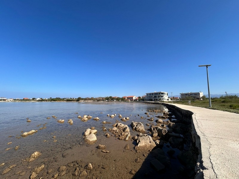 Linia brzegowa z promenadą i czystym morzem w Privlaka