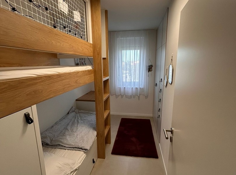 Pokój dziecięcy z łóżkiem piętrowym i szafami wnękowymi