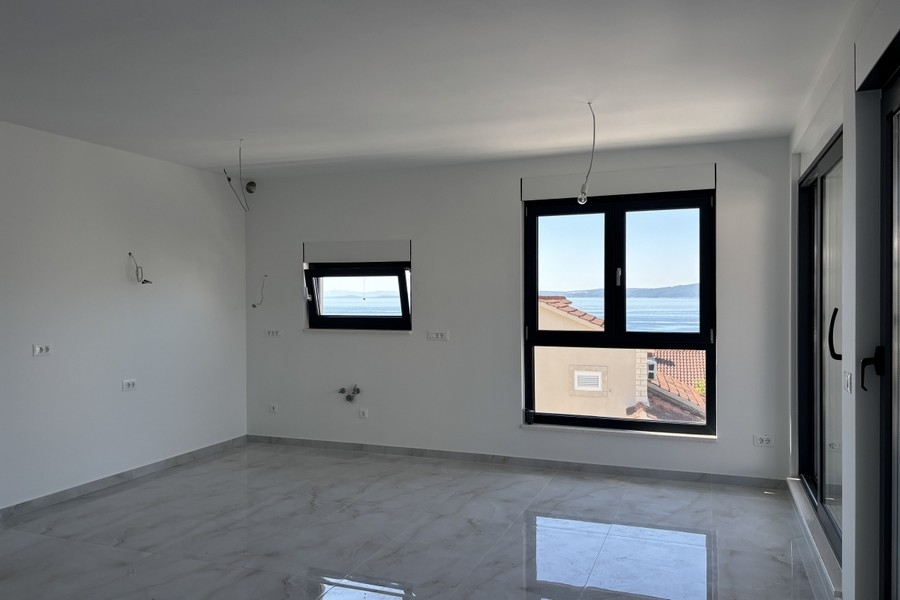 Otwarty salon z wyjściem na balkon i widokiem na morze
