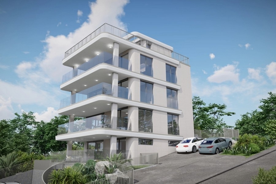 Nowy budynek z przestronnymi balkonami i szklanymi balustradami na zboczu wzgórza