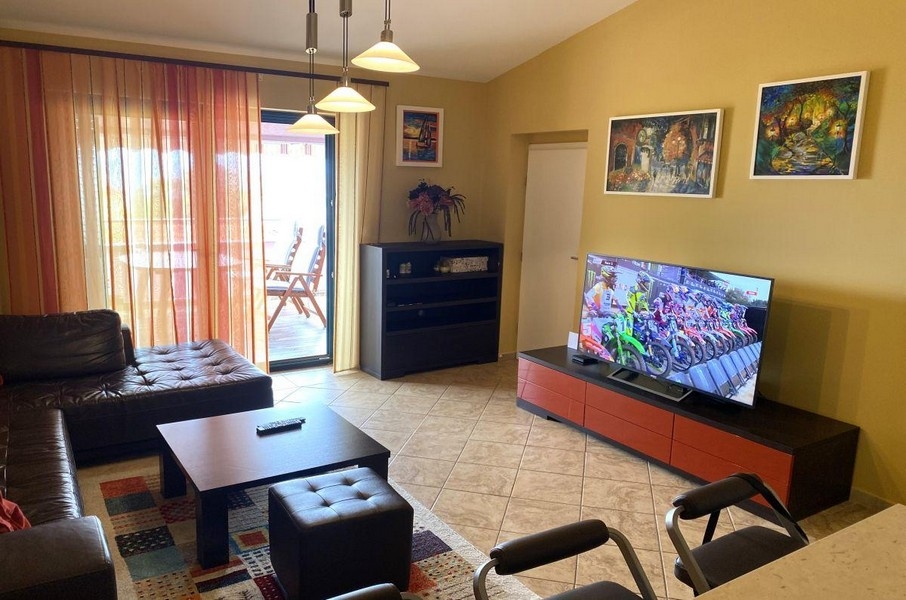 Część dzienna z sofą i wyjściem na balkon w apartamencie wakacyjnym na Krk