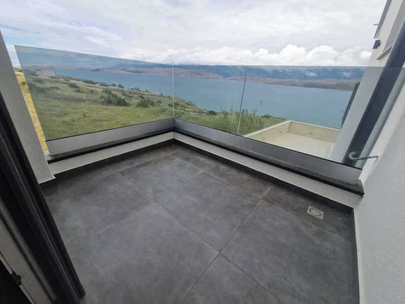 Zadaszony taras ze szklanymi balustradami i widokiem na morze