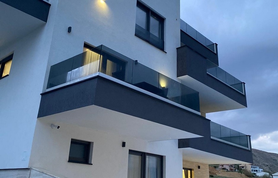 Nowoczesny budynek mieszkalny z balkonami i szklanymi balustradami w Pag