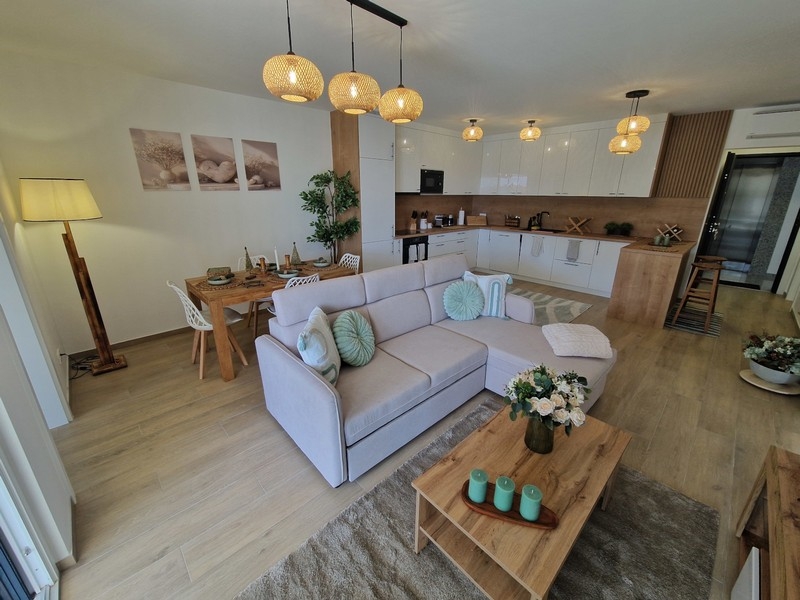 Jasny salon z nowocześnie wyposażoną kuchnią