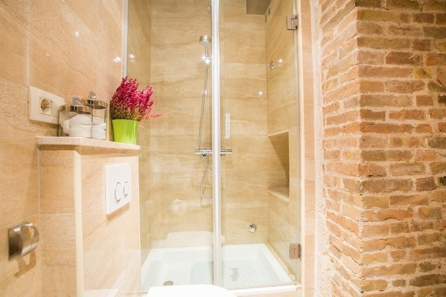 Łazienka z prysznicem i ścianą z kamienia naturalnego