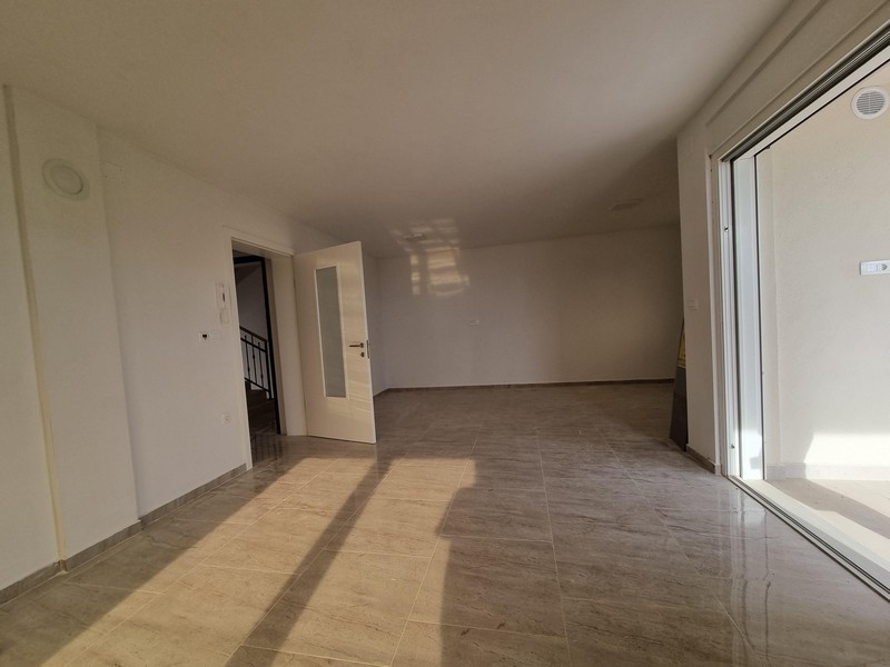 Pokój dzienny w nowym mieszkaniu z wyjściem na balkon w Njivice