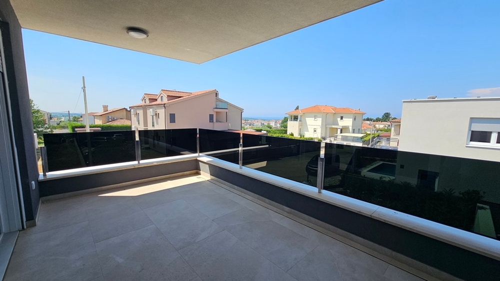 Zadaszony taras ze szklanymi balustradami i widokiem na okolicę