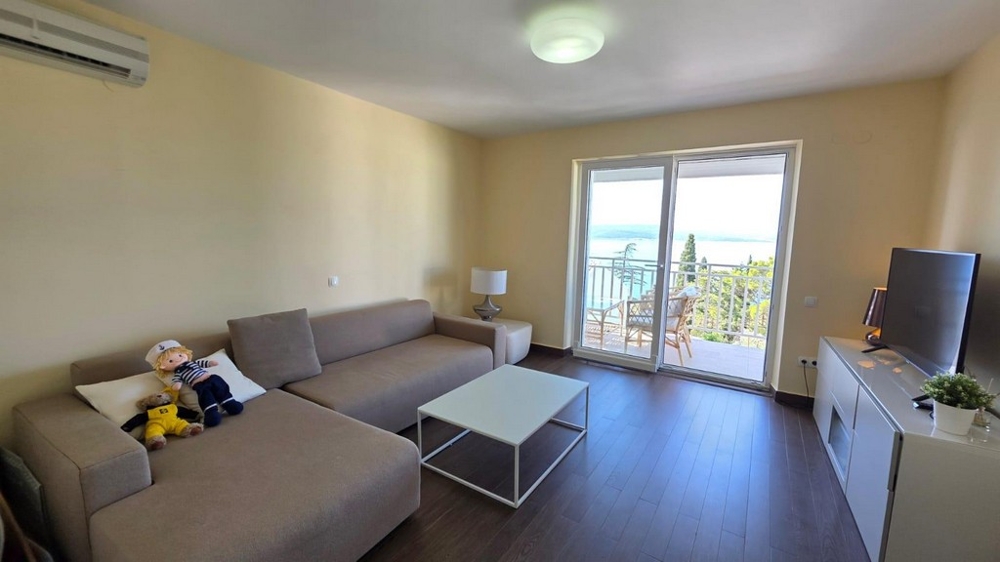 Pokój dzienny z sofą i wyjściem na balkon