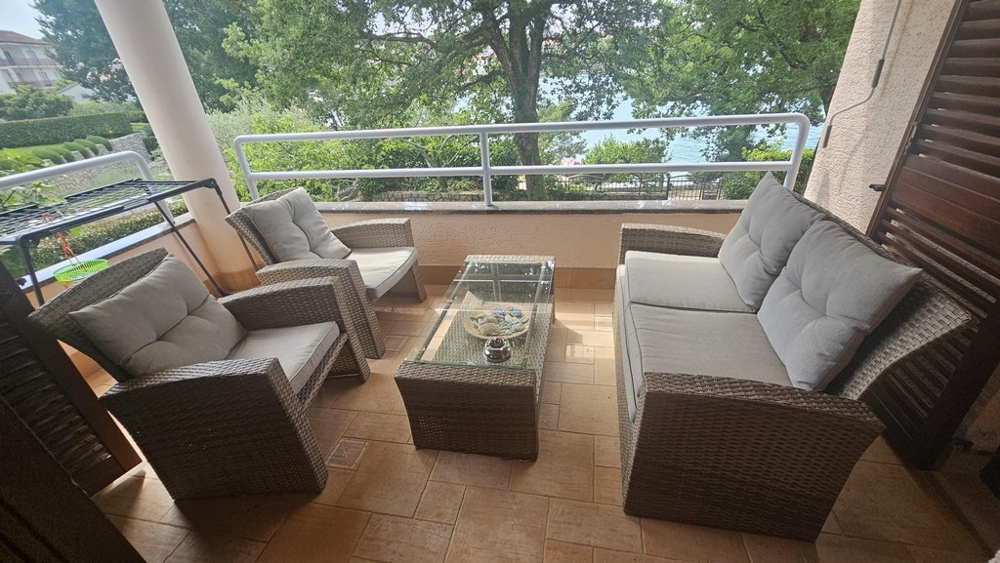 Zadaszony balkon z meblami wypoczynkowymi i widokiem na morze