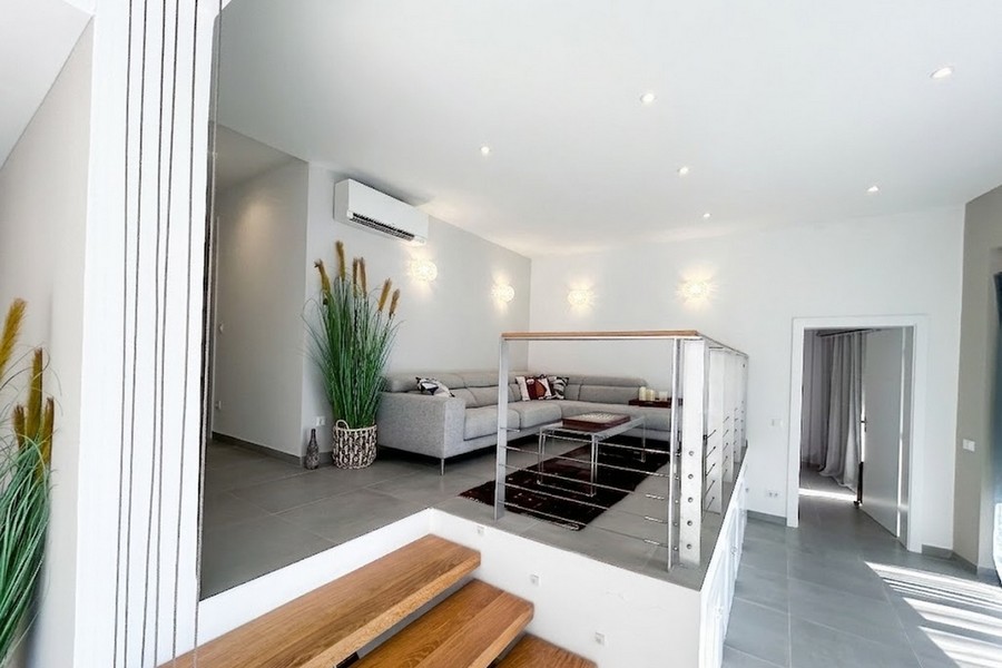 Podwyższona część dzienna z sofą i drewnianymi schodami, apartament Korcula
